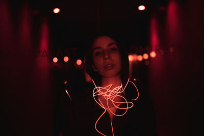 Portrait of young woman with illuminated cable