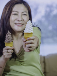 Portrait of young woman holding ice cream cone