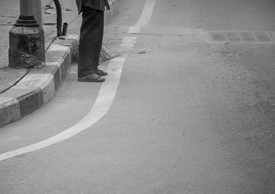 Low section of man standing on road