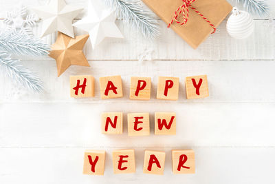 Directly above shot of happy new year text with christmas decorations on table