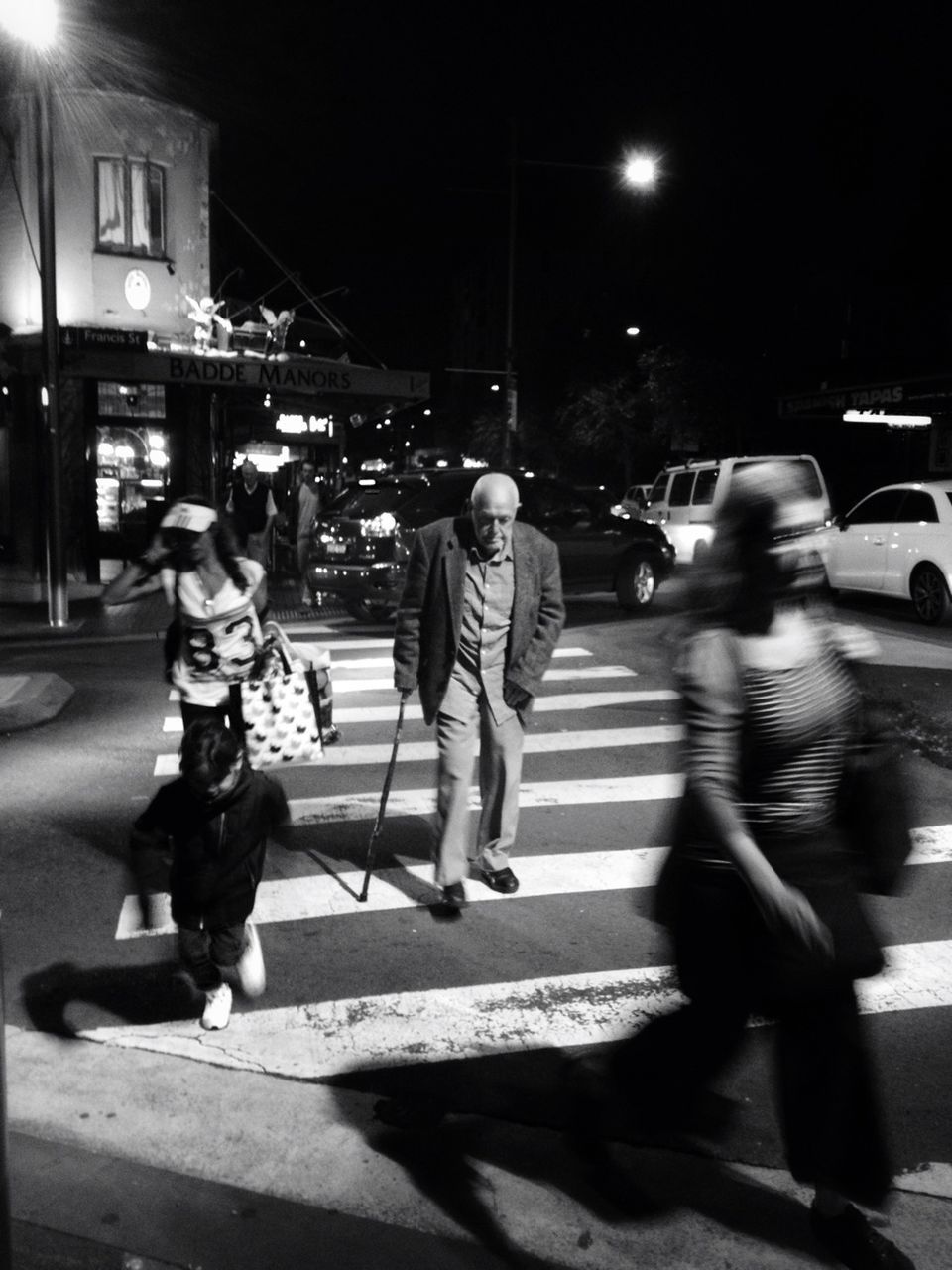 street, full length, lifestyles, city, city life, night, transportation, walking, men, casual clothing, land vehicle, leisure activity, city street, road, building exterior, car, person, rear view, mode of transport