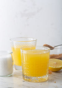 Close-up of yellow juice in glass on table