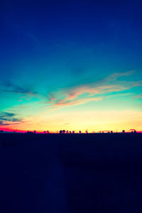 Scenic view of silhouette field against sky at sunset