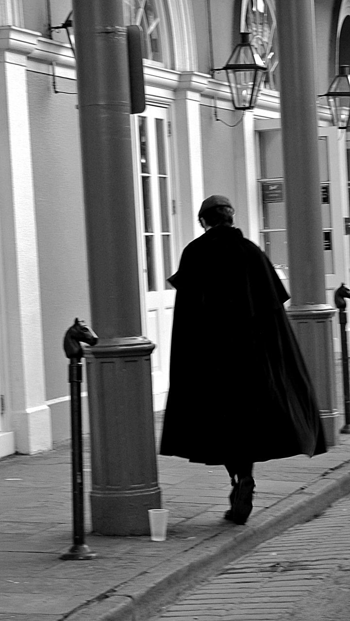 REAR VIEW OF MAN WALKING IN BUILDING