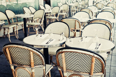 Empty tables and chairs at sidewalk cafe