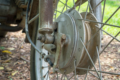 Close-up of rusty machine part on field