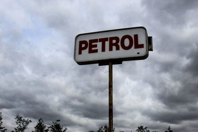 Low angle view of road sign against sky