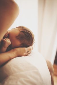 Rear view of boy sleeping on bed at home