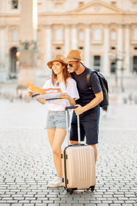 Happy tourists looking at a map and choose a hotel. couple of tourists on vacation in rome, italy. 