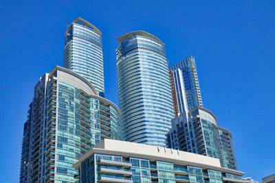 Low angle view of modern buildings against blue sky