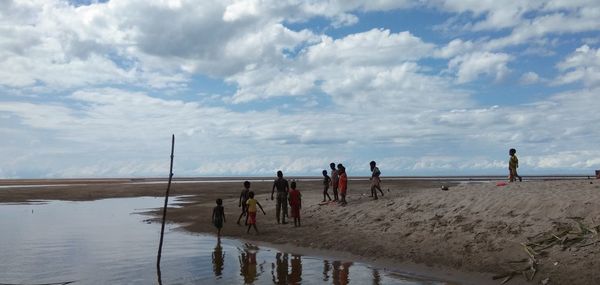 People on beach against sky