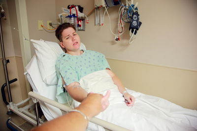 Mid adult woman sitting on hospital bed