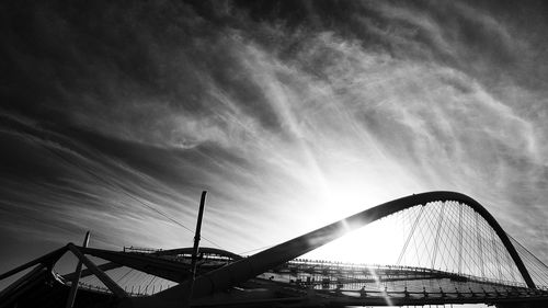 Low angle view of bridge against cloudy sky