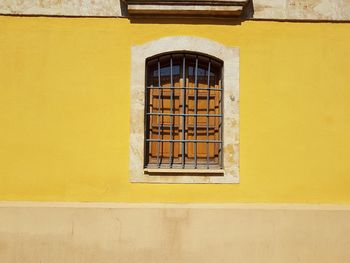 Rustic window, colorful facade, yellow wall