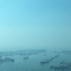 Boats sailing in sea against clear blue sky