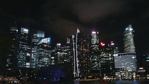 Low angle view of illuminated cityscape against sky at night