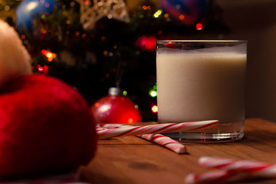 Close-up of drink by candy canes in glass on table