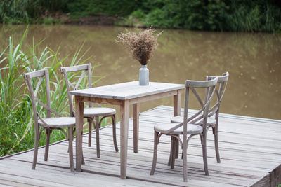 Empty chairs and table against plants