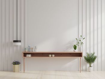 Potted plants and table against wall at home