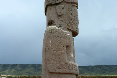 Low angle view of stone column against sky