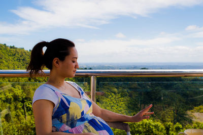 Beautiful woman standing by sea against sky