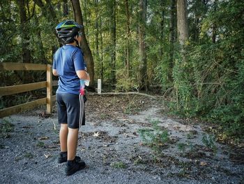 Full length rear view of man standing in forest