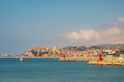 Scenic view of sea by buildings against sky