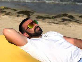 Midsection of man relaxing on beach
