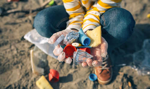 Low section of child holding umbrella on land