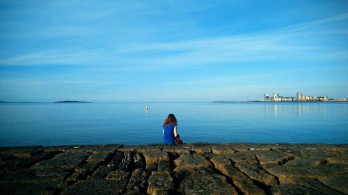 Rear view of woman looking at sea against sky