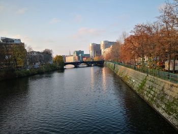 River amidst buildings in city against sky