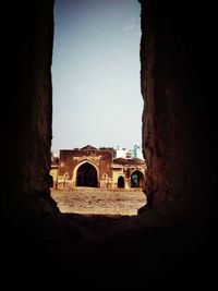 Old building against sky seen through hole