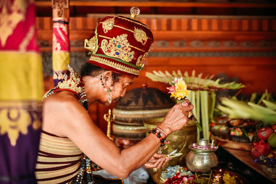 Midsection of woman holding candles in temple