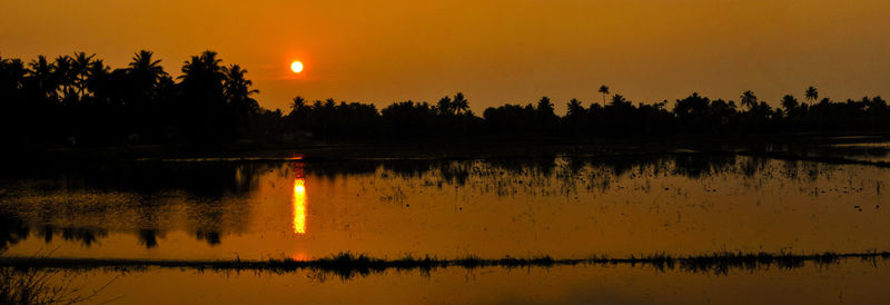 Scenic view of lake against orange sky