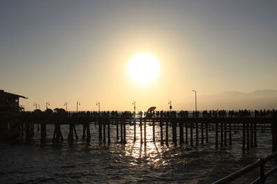 Silhouette pier on sea against sky during sunset