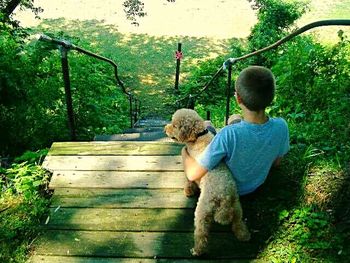 Full length of woman sitting on tree trunk