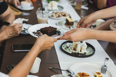 Happy family enjoy eating brownie cake in cafe.
