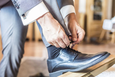 Low section of man tying shoelace