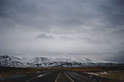 Road leading towards snowcapped mountains 