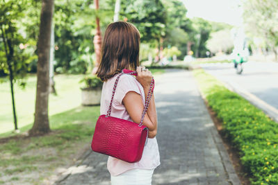 Rear view of woman standing against trees
