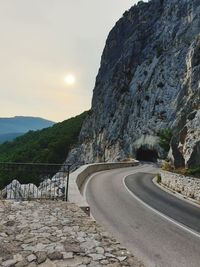 Road leading towards mountains against sky