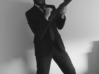 Low angle view of man holding umbrella against sky