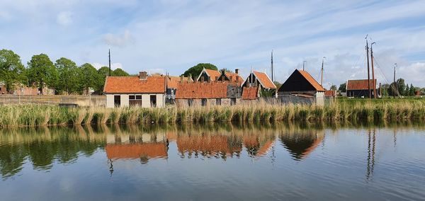 Historic houses of the open air museum reflecting on water