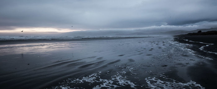 Scenic view of sea against cloudy sky