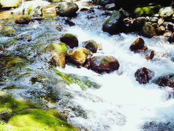 High angle view of stream flowing through rocks