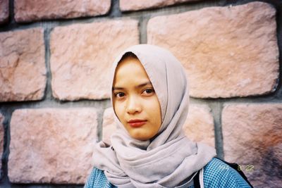 Portrait of woman standing against wall