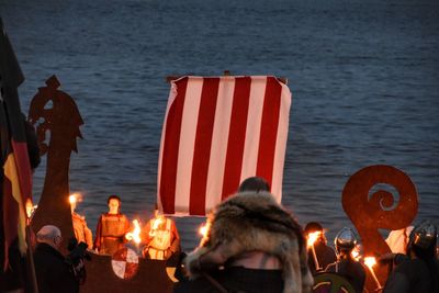 People with fire at beach during night