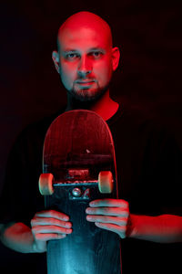 Portrait of young man wearing mask against black background