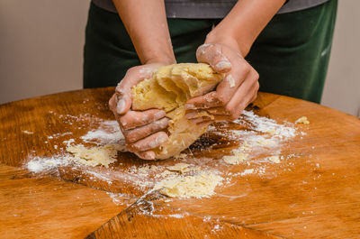 The cook kneads the cookie dough with his hands