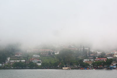 River amidst buildings in city against sky